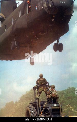 SENIOR AIRMAN Michael Hafstad und SENIOR AIRMAN Adrian Faison, beide Bauingenieure vom 820. Red Horse Squadron, Nellis Air Force Base, Nevada, bereiten sich darauf vor, einen Traktor auf einem Anhänger zu einem CH-47 Chinook Hubschrauber zu beladen. Die CH-47 wird die Ausrüstung von Kumaka nach Camp Stephenson, Timehri Guyana, zurückschicken. Die 820., war in Kumaka, um das bestehende regionale Krankenhaus im Rahmen dieser ersten kombinierten humanitären und bürgerschaftlichen Hilfsübung zwischen den Vereinigten Staaten und Guyana zu renovieren. Militärpersonal der Luftwaffe, Luftwaffenreserve und Nationalgarde, Armee, Army Nation Stockfoto