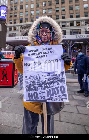 New York, New York, USA. 14. Januar 2023. Ein Anti-Kriegs-Demonstrante hält ein Zeichen, das gegen die Erweiterung der Nordatlantik-Vertragsorganisation (NATO) in der Ukraine auf dem Times Square protestiert. Die Teilnehmer forderten die NATO, ein Sicherheitsbündnis aus 30 Ländern, auf, eine friedliche Lösung auszuhandeln, nachdem der russische Präsident Wladimir Putin vor fast 11 Monaten eine groß angelegte Invasion der Ukraine eingeleitet hatte. (Kreditbild: © Michael Nigro/Pacific Press via ZUMA Press Wire) NUR ZUR REDAKTIONELLEN VERWENDUNG! Nicht für den kommerziellen GEBRAUCH! Kredit: ZUMA Press, Inc./Alamy Live News Stockfoto