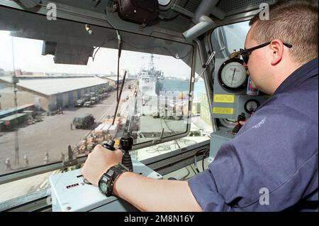 JOHN R. Deschamps Jr., Mate der US Navy Boatswain's Second Class, lädt Maschinen mit dem Kran auf das Landingdock, USS OAK HILL (LSD 51), während er sich auf das Abfahren aus einem kuwaitischen Hafen vorbereitet. Das Schiff befindet sich in Kuwait als Teil eines Aufbaus von Streitkräften in Südostasien als Reaktion auf die Weigerung Iraks, von der UNO unterstützte Waffeninspektionen durchzuführen. Basis: USS Oak Hill (LSD 51) Land: Kuwait (KWT) Stockfoto