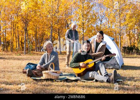 Glückliche Familie, die im Herbst für ein Picknick campen geht Stockfoto