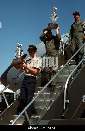 Kevin Rimer, 97. Logistics Group Maintenance, und USAF Major Mike Smith, 54. Air Tanken Squadron, tragen stolz die Siegertrophäen aus dem Rodeo 98 Wettbewerb, während USAF Major Tim Reader, 55. Air Tanken Squadron, der Gruppe die Flugzeugtreppe hinunter folgt. Mr. Rimer, MAJ Smith und MAJ Reader sind alle Mitglieder des USAF KC-135 Stratotanker-Teams von Altus AFB, Oklahoma, das nach McChord AFB, Washington reiste, um am Rodeo 98-Wettbewerb teilzunehmen. Das Team von Altus AFB gewann das beste KC-135 On Load Off Load Team, den besten KC-135 Tanker Wing und die beste Tanken Crew, A Stockfoto