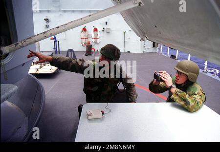 PO1 Shelby Cornelius (links) aus der mobilen Einheit 2 der explosiven Ordnance Disposal (EOD), Whidbey Island, Washington, arbeitet mit Australian Clearance Diver LT Neil Greene (rechts) zusammen, um digitale Bilder von der kanadischen Fregatte HMCS REGINA aufzunehmen, während sie versuchen, eine feststeckende Pistolenhalterung während der Übung RIMPAC 98 zu entfernen. Betreff Betrieb/Serie: RIMPAC '98 Bundesstaat: Hawaii (HI) Land: Vereinigte Staaten von Amerika (USA) Stockfoto