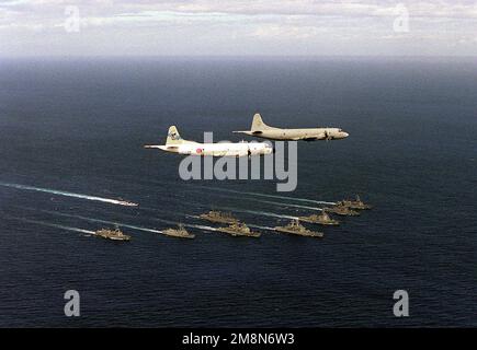 Ein US Navy P-3 Orion-Flugzeug der Skinny Dragons von Patrouillenstaffel 4 führt eine japanische P-3 im Flug über eine bilaterale Truppe von US- und japanischen Schiffen während der Übung RIMPAC '98. Die in Formation befindlichen Schiffe werden von der kalifornischen Klasse USS CALIFORNIA (CGN 36) angeführt, flankiert von den Kreuzern der Ticonderoga-Klasse USS CHANCELLORSVILLE (CG 62) und USS PORT ROYAL (CG 73), der Oliver Hazard Perry-Klasse-Fregatte USS VANDERGRIFT (FFG 48) und begleitet von japanischen Seeschiffen der Seeschiffskräfte JDS KIRISHIMA (DDG 174), JDS SHIRANE (DDH 143), JDS MURASAME (DD 101), JDS HAARUSAME (DD 102) UND JDS TOWADA (AOE 422 Stockfoto