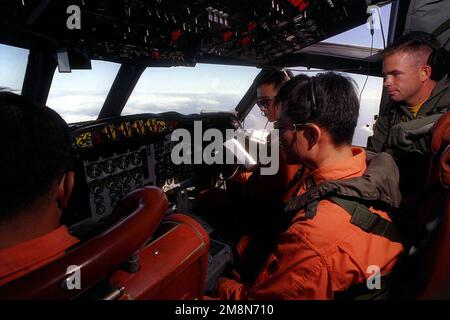 An Bord eines ROKN P-3C Orion-Flugzeugs überwachen koreanische Crewmitglieder die Instrumente, während US Navy Lieutenant Jeff G. Conway von VP-47 die Verfahren beobachtet. Betreff Betrieb/Serie: RIMPAC '98 Land: Pazifik (POC) Stockfoto