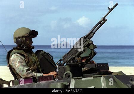 US Marine Corps SGT Steven Pipes von Co Ein 1. Light Pmored Reconnaissance, Camp Pendleton, Kalifornien, ist in seinem gepanzerten Aufklärungsfahrzeug bereit, sich mit dem 7,62 FN mag Maschinengewehr während der Übung RIMPAC '98 gegen unfreundliche Truppen zu stellen. Am Horizont kann man die Whidbey Island Class USS HARPERS FERRY (LSD 49) sehen. Betreff Betrieb/Serie: RIMPAC '98 Base: Barking Sands, Kauai Bundesstaat: Hawaii (HI) Land: Vereinigte Staaten von Amerika (USA) Stockfoto