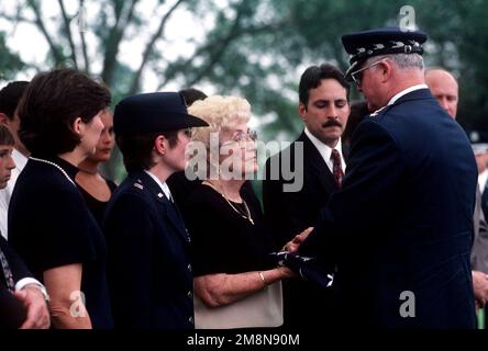 Gene Blassie (2. von links) erhält eine gefaltete amerikanische Flagge vom USAF-STABSCHEF Michel Ryan während der Beerdigung von Oberleutnant Michael Blassie auf dem Jefferson Barracks National Cemetery, Missouri. 1lt Blassie wurde am 11. Mai 1972 in Südvietnam abgeschossen und getötet. Eine Verwechslung mit Hundemarken und der Identifizierung der Leiche führte dazu, dass die Überreste als Unbekannt aufgeführt und im Grab des Unbekannten Soldaten auf dem Arlington National Cemetery (nicht abgebildet) begraben wurden. Anhand von DNA-Tests am 14. Mai 1998 wurden die Überreste als Überreste von 1LT Blassie identifiziert und zu seinen Ehren abgehalten. Dieses Bild ist in t zu sehen Stockfoto