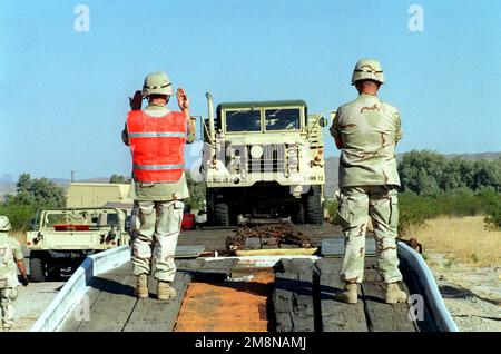 Army STAFF Sergeant Kooker (rechts) und SPEZIALIST Hart (links) von Delta 3/43, 11. Brigade Air Defense Artillery Fort Bliss, Texas, führt einen 5-Tonnen-taktischen Lastwagen M939A2 sicher von einem Tieflader. Basis: Marine Corps Air Station, Yuma Bundesstaat: Arizona (AZ) Land: Vereinigte Staaten von Amerika (USA) Stockfoto