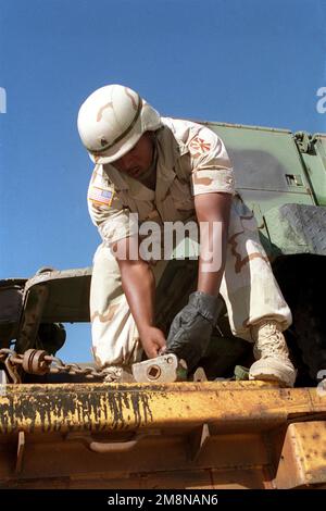 Sergeant McClain, Delta 3/43, 11. Brigade Air Defense Artillery Fort Bliss, Texas, lockert Verzurrketten vor dem Abladen eines Geländerwagens während WAFFEN- UND TAKTIKANWEISUNGEN 1-99. Betreff Operation/Serie: WAFFEN- UND TAKTIKANWEISUNGEN 1-99 Base: Marine Corps Air Station, Yuma Bundesstaat: Arizona (AZ) Land: Vereinigte Staaten von Amerika (USA) Stockfoto