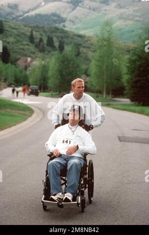 Gerade auf Medium Shot von USAF SENIOR AIRMAN Walter Boldish, der seinen Freund Jason Shumway, gelähmt bei einem Tauchunfall, während des Park City, Utah Marathon, im Rollstuhl schiebt. SRA Boldish schwor Shumway, dass er keinen Marathon laufen würde, bis sie es als Team geschafft hätten. Basis: Park City Bundesstaat: Utah (UT) Land: Vereinigte Staaten von Amerika (USA) Stockfoto