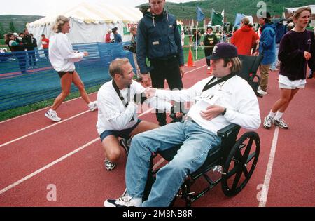 Gerade auf Medium Shot von USAF SENIOR AIRMAN Walter Boldish, während er sich neben den Rollstuhl seines Freundes Jason Shumway hockt, gelähmt während eines Tauchunfalls und ihm nach dem Park City, Utah Marathon, gratuliert. Boldish und Shumway sammelten Geld, um Waisenkinder nach Disney World zu schicken, und im nächsten Jahr wollen sie die Rückenmarksforschung unterstützen. Basis: Park City Bundesstaat: Utah (UT) Land: Vereinigte Staaten von Amerika (USA) Stockfoto