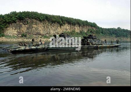 Zwei m2 Bradley-Kampffahrzeuge, die der 2-9. Infanterie, Camp Casey, Republik Korea (ROK), zugewiesen sind, sitzen auf einer teilweise montierten Pontonbrücke, die von den 50. Engineers, 1. Platoon, Camp LaGuardia, ROK, gebaut wurde, während sie den Imjin River, ROK, überqueren, während einer Übung zum Brückenbau am 22. Oktober 1998. Viele der Teilnehmer an der heutigen Übung sind Offiziere, die gemäß dem US Army Officer Professional Development Program teilnehmen, einem Programm zur Verbesserung der Teambildung und der Soldatenbildung. Betreff Betrieb/Serie: KOREA CD Base: Imjin River Country: Republik Korea (KOR) Stockfoto