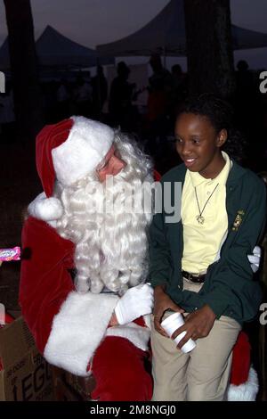 US Army Sergeant First Class Jimmie Sutterfield, Director of Plans, Training, Mobilisation and Security in Fort McPherson, Georgia, spielt den Weihnachtsmann und hört sich die Weihnachtswünsche einer jungen Dame im Fort Gillem, GA, Christmas Tree Lighting an. Basis: Fort Gillem Staat: Georgia (GA) Land: Vereinigte Staaten von Amerika (USA) Stockfoto