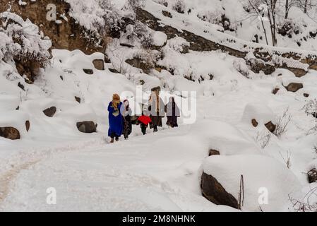 Srinagar, Indien. 15. Januar 2023. Die Bewohner gehen einen schneebedeckten Hügel hinunter nach einem schweren Schneefall in den Außenbezirken von Srinagar. Aufgrund des starken Schneefalls gab es mehrere Lawinen an verschiedenen Orten Kaschmirs. Der Zeitraum von 40 Tagen von Dezember 21 bis Januar 31., auch bekannt als Chilai Kalan, in Kaschmir gilt als der wichtigste Zeitraum, wenn es schneit, wird der Zustand noch schlimmer. Kredit: SOPA Images Limited/Alamy Live News Stockfoto