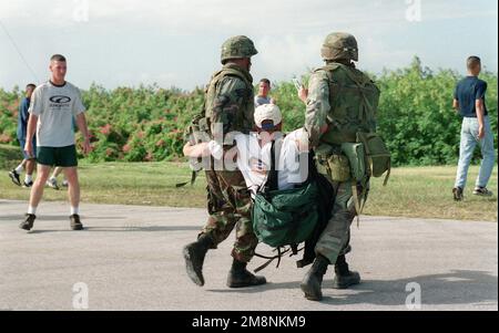 US Army (USA) Soldaten, die der A/Company zugeteilt sind, 1. Bataillon, 17. Infanteriedivision, entfernen einen Demonstranten während einer Scheindemonstration, während sie Techniken zur Bekämpfung von Ausschreitungen praktizieren, die Teil der nichtkombattanten Evakuierungsoperationen (NEO) am Orot Point, Guam sind, die während der TANDEM-SCHUBÜBUNG '99 durchgeführt wurden. Betrifft Operation/Serie: TANDEM-SCHUBBASIS '99: Orot Point Staat: Guam (GU) Land: Nördliche Marianen (MNP) Stockfoto