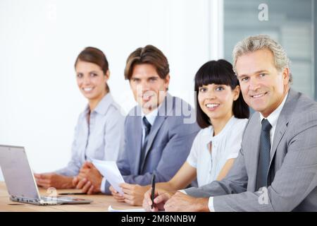 Sein Team zum Erfolg führen. Porträt eines Teams von Geschäftsleuten, die zusammen an einem Notebook arbeiten. Stockfoto