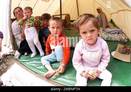 Ethnische albanische Kinder und zwei Mütter aus dem Kosovo sind neugierig auf die Kamera (nicht abgebildet) in einem türkisch geführten Flüchtlingslager in Albanien, 5. Mai 1999. In Albanien gibt es mehrere Lager, die von den alliierten NATO-Ländern errichtet und unterhalten werden, um Menschen zu helfen, die aus dem Kosovo fliehen. Diese Mission dient der direkten Unterstützung der Operation Sustain Hope und der Alliierten Truppe. Operation/Serie: SUSTAIN HOPE Land: Unbekannt Stockfoto