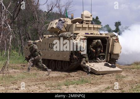 Linke Seite, Rückansicht eines M2A2 Bradley-Kampffahrzeugs, während 1. der 9. Kavallerie, 1. Kavalleriedivision aus dem Fahrzeug kommen, während sie am 19. Mai 1999 auf dem Owl Creek-Angriffskurs in Fort Hood, Texas, ein Infanterie-Taktiktraining (HITP) durchführen. Basis: Fort Hood Bundesstaat: Texas (TX) Land: Vereinigte Staaten von Amerika (USA) Stockfoto