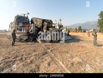 Ein M939 (6x6) 5 Tonnen schwerer Frachtwaggon aus der 26. Marine Expeditionary Unit (MEU) wird von der Rampe eines Air Cushion Landing Craft (LCAC) am Strand von Litohoro, Griechenland, geführt. Die erste Welle der USA Marines, die der 26. Marineexpeditionstruppe (MEU) zugewiesen wurden, kamen in den frühen Morgenstunden zur Unterstützung der NATO-Friedensmission im Kosovo an Land in Litohoro. Die ersten, die vom Amphibious Ship USS PONCE (LPD 15) (nicht abgebildet) kamen, befanden sich an Bord von Amphibious Assault Vehicles (AAVs) (nicht abgebildet), gefolgt von Landing Craft Utility Boats (LCUs) (nicht abgebildet) und Landing Craft Air Polsters (L Stockfoto