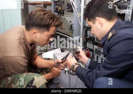 US Navy Electronics Technician 3. Class James Kyne arbeitet mit einem chilenischen Seemann an Bord des chilenischen Flagschiffs BLANCO ENCALADA (DLH 15) in Valparaiso, Chile, und installiert eine Datenverbindung als Teil der Übung TEAMARBEIT SÜD '99. DIE US-amerikanischen, kanadischen und chilenischen Streitkräfte werden bis Juli bei Übungen vor der Küste Südamerikas zusammenarbeiten. Betreff Betrieb/Serie: TEAMWORK SÜD '99 Basis: Blanco Encalada (DLH 15) Stockfoto