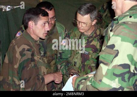 Brigadegeneral John Craddock (rechts), Commander, USA Kosovo-Streitkräfte/ Joint Task Force Falcon , hört Oberst Ahmed Isusi, Befehlshaber der Zone Karadak der Kosovo-Befreiungsarmee, nahe Cernica, Kosovo. Die beiden Führer kamen zusammen, um ein lokales Abkommen zu unterzeichnen, das eine schrittweise Demobilisierung und Entmilitarisierung der UCK-Truppen in den USA vorsieht Sektor zur Unterstützung der NATO-Operation Joint Guardian. Betrifft Operation/Serie: GEMEINSAMER VORMUNDSTAAT: Kosovo-Land: Jugoslawien (YUG) Stockfoto