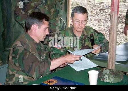 Brigadegeneral John Craddock (rechts), Commander, USA Kosovo-Streitkräfte/Joint Task Force Falcon, tauscht Dokumente mit Oberst Ahmed Isusi, Befehlshaber, Karadak-Zone der Kosovo-Befreiungsarmee, nahe Cernica, Kosovo. Die Unterzeichnung des Dokuments war Teil eines lokalen Abkommens, das eine schrittweise Demobilisierung und Entmilitarisierung der UCK-Streitkräfte in den USA einführte Sektor zur Unterstützung der NATO-Operation Joint Guardian. Betrifft Operation/Serie: GEMEINSAMER VORMUNDSTAAT: Kosovo-Land: Jugoslawien (YUG) Stockfoto