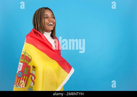 Glückliche afrikanerin, eingewickelt in eine spanische Nationalflagge Stockfoto