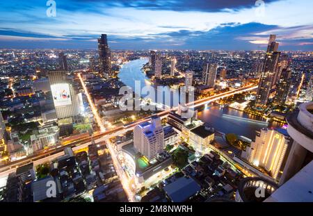 Bangkok, Thailand-Dezember 04 2022: Von einem Wolkenkratzer aus gesehen beleuchten Tausende von Lichtern Thailands Hauptstadt und Lichtpfade von Meeting Stockfoto