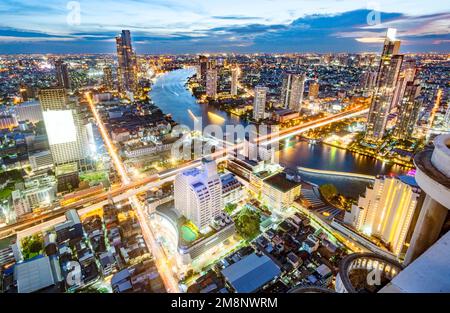 Bangkok, Thailand-Dezember 04 2022: Von einem Wolkenkratzer aus gesehen beleuchten Tausende von Lichtern Thailands Hauptstadt und Lichtpfade von Meeting Stockfoto