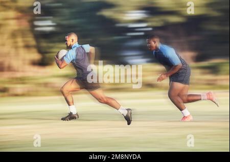 Ein Rugbyspieler mit gemischten Rassen läuft vor einem Gegner weg, während er versucht, während eines Rugby-Spiels draußen auf einem Feld einen Versuch zu erzielen. Hispanischer männlicher Athlet Stockfoto