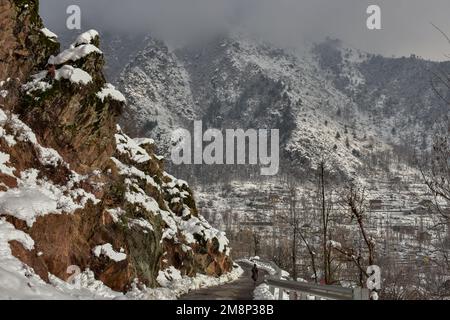 Ein Junge geht durch eine schneebedeckte Straße nach einem frischen Schneefall am Stadtrand von Srinagar. Das Wetter verbesserte sich im Kaschmir-Tal nach Tagen mit moderatem bis starkem Schneefall und Regen. In der Zwischenzeit wurden am Samstag Lawinen im Bezirk Bandipora und im Bahnhof Sonamarg gemeldet, bei denen es in den letzten Tagen zu moderaten bis schweren Schneefällen kam. Dies ist der zweite Vorfall, der in den letzten zwei Tagen in der beliebten Hill Station gemeldet wurde. Zwei Arbeiter starben am Donnerstag, als eine Lawine die Baustelle einer Baufirma in Sonamarg traf. (Foto: Saqib Majeed/SOPA Images/Sipa USA) Stockfoto