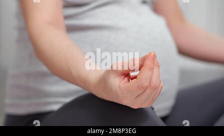 Schwangere meditieren zu Hause in Lotusposition Stockfoto