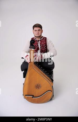 Der Mensch spielt ein musikalisches, ethnisch-ukrainisches Instrument, den Sieg der Unabhängigkeit und Unbesiegbarkeit der Ukraine, den Ruhm der Helden, den Musiker in Stickerei Stockfoto