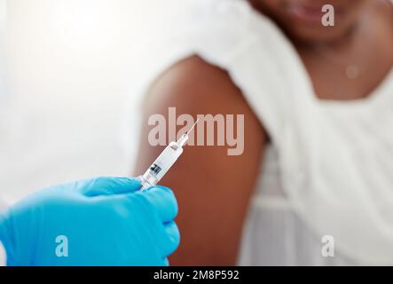 Nahaufnahme eines Arztes, der eine Nadel hält. Hand eines Arztes, der eine mit einem Impfstoff gefüllte Nadel hält. Ein Arzt, der eine Spritze hält. Patient bekommt Stockfoto