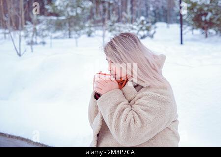 Eine Frau, die heißes Getränk aus einer Tasse trinkt Stockfoto