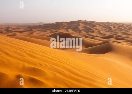 Das rote Deset außerhalb von Dubai, mit einer Düne im Vordergrund und einem Dünen, die sich bis zum Horizont im Hintergrund erstrecken Stockfoto