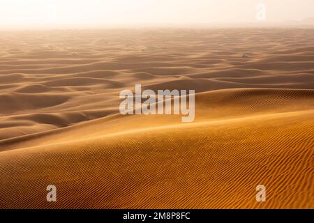 Das rote Deset außerhalb von Dubai, mit einer Düne im Vordergrund und einem Dünen, die sich bis zum Horizont im Hintergrund erstrecken Stockfoto