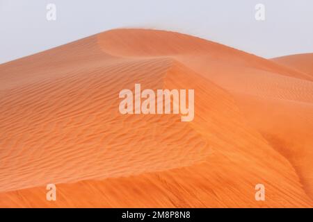 Nahaufnahme des Berges der Wüstendünen, mit Sand, der im Wind treibt Stockfoto