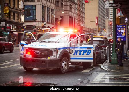 New York City Manhattan 8. Avenue NYPD Verkehrspolizisten entfernen ein geparktes Auto mit einem Ford Abschleppwagen Stockfoto