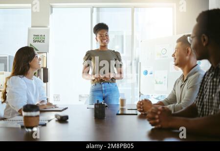 Eine Gruppe von Geschäftsleuten, die sich in einem Büro treffen. Junge afroamerikanische Geschäftsfrau, die während einer Präsentation bei A spricht Stockfoto