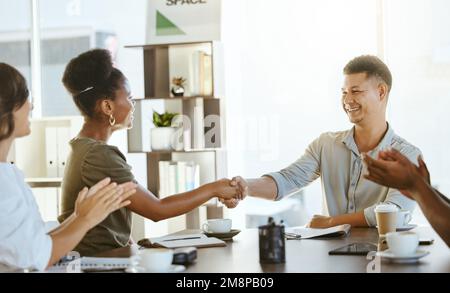 afroamerikanische Geschäftsfrau und Geschäftsmann gemischter Rassen schütteln sich die Hand, während ihre Kollegen während eines Meetings bei der Arbeit die Hand klatschen. Boss, Ich Bin'S Stockfoto