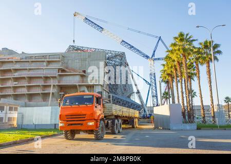 Ein Lkw mit Anhänger kam an, um Baumaterial auf einer Baustelle zu entladen Stockfoto