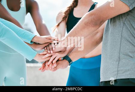 Nahaufnahme einer vielfältigen Gruppe sportlicher Menschen, die ihre Hände auf einem Stapel stapeln, um Einheit, Unterstützung und Vertrauen auszudrücken. Motivierte Athleten im Kreis Stockfoto