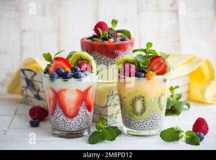 Geschichtete Beeren, Obst und Chiasamen Smoothies in Gläsern für ein gesundes Frühstück. Stockfoto