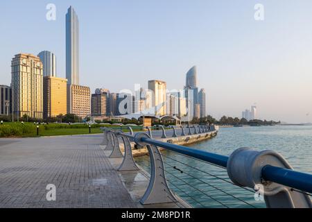 Weitwinkelblick auf die Promenade Corniche in Abu Dhabi bei Sonnenuntergang, mit den Wolkenkratzern mit Blick auf den persischen Golf Stockfoto