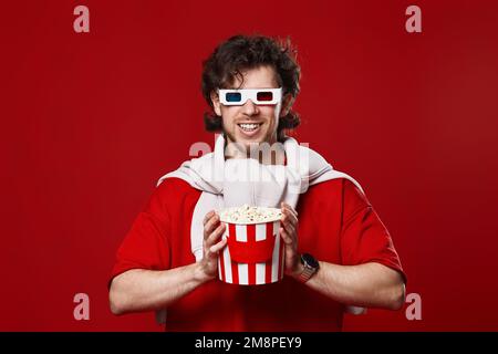 Ein Mann in 3D-Brille mit einem großen Eimer Popcorns Stockfoto