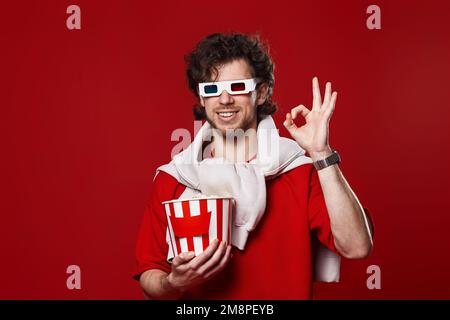 Ein Mann in 3D-Brille mit einem großen Eimer Popcorns Stockfoto
