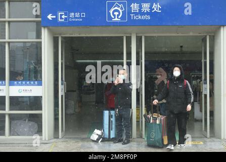 HANGZHOU, CHINA - 15. JANUAR 2023 - Passagiere trauen sich dem Schnee, um den Bahnhof von Hangzhou zu betreten und den Zug nach Hause zu nehmen, um den MondNeujahrsfeiertag zu feiern.i Stockfoto