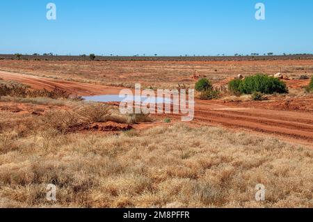 White Cliffs Australia, Blick über die Landschaft mit roter Schotterstraße nach Regen Stockfoto