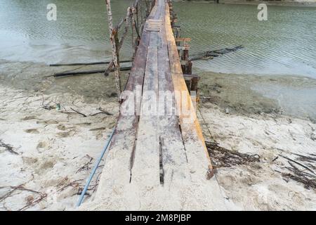 Kopfwasser mit einer Holzbrücke am Rand eines weißen Sandstrands in Naturlandschaft Stockfoto