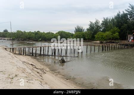 Kopfwasser mit einer Holzbrücke am Rand eines weißen Sandstrands in Naturlandschaft Stockfoto